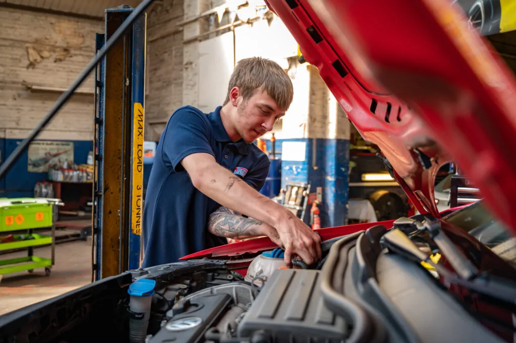 Mechanic working under bonnet of car