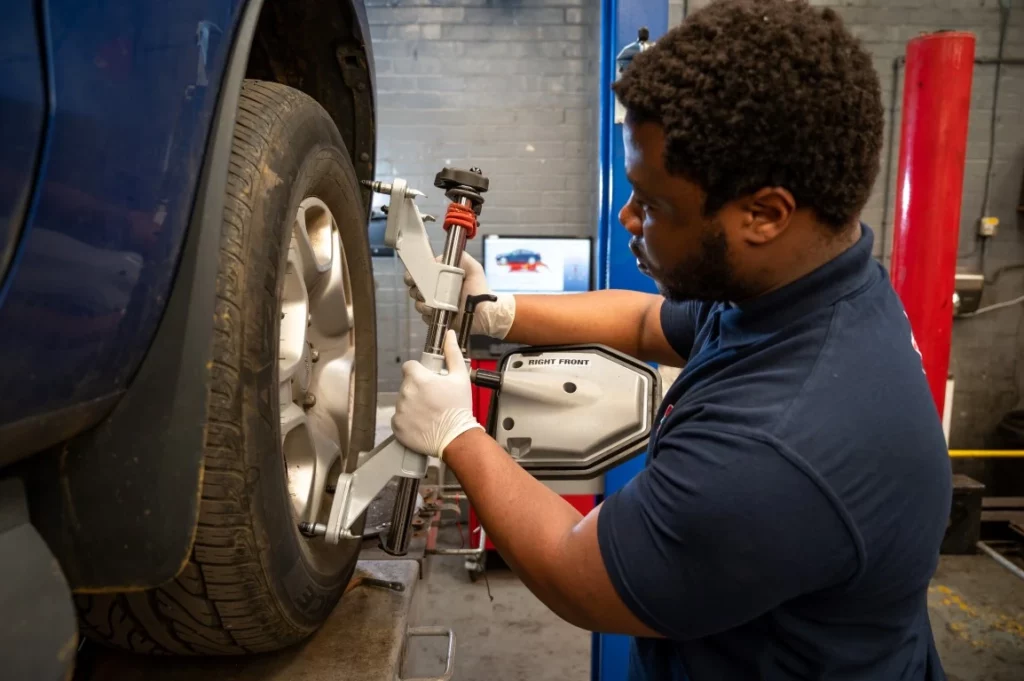 Technician at K Brown Auto Repairs carrying out 4-wheel alignment on a car in the workshop