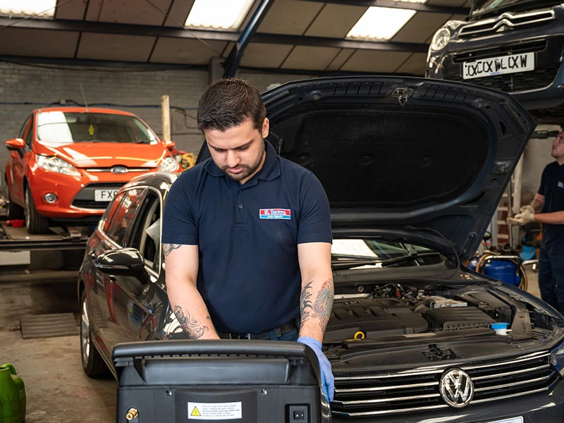 Technician conducting air con service on car in K Brown Auto Repairs' King's Lynn workshop 