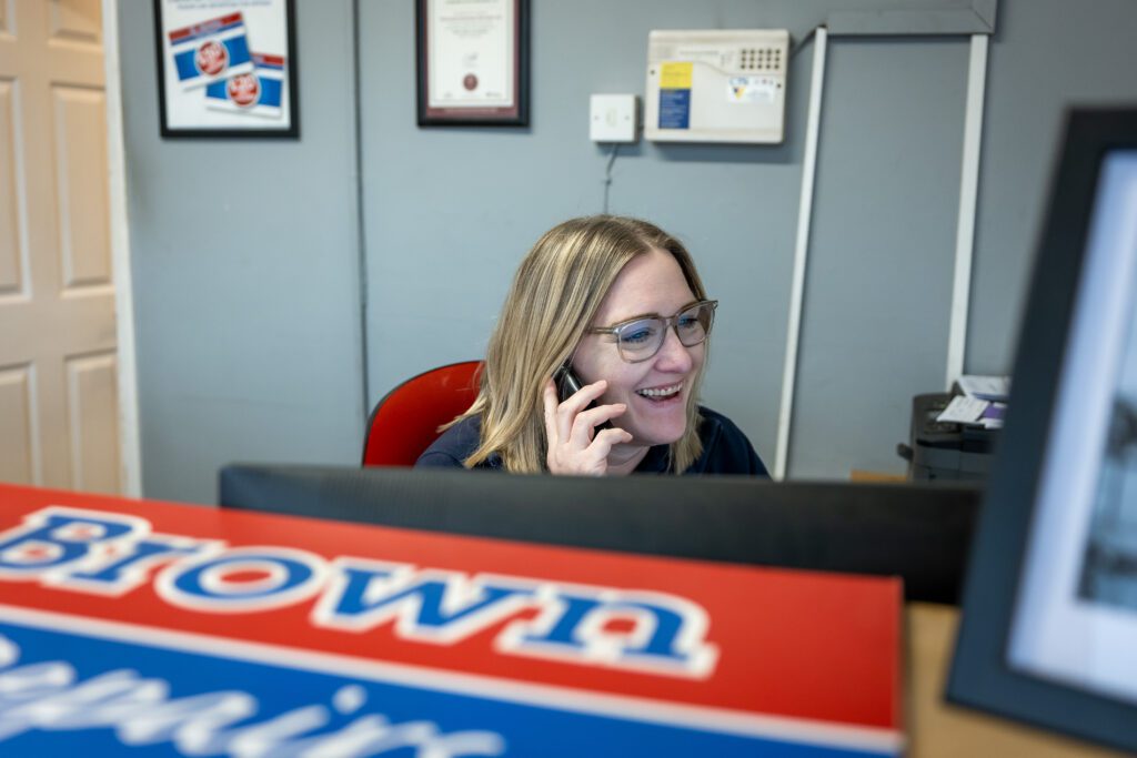 Receptionist at K Brown Auto Repairs Hunstanton on phone behind desk